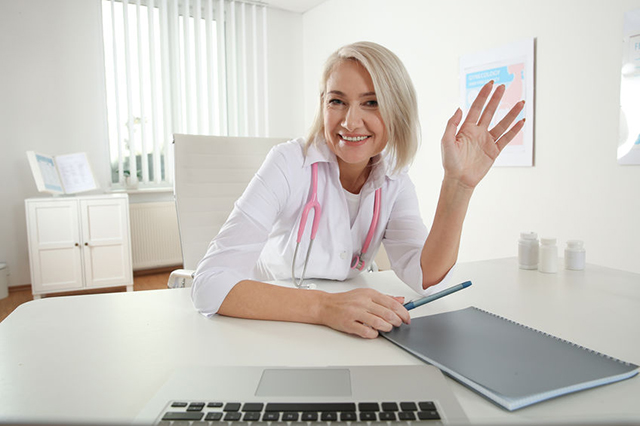 Image of a smiling GP waving